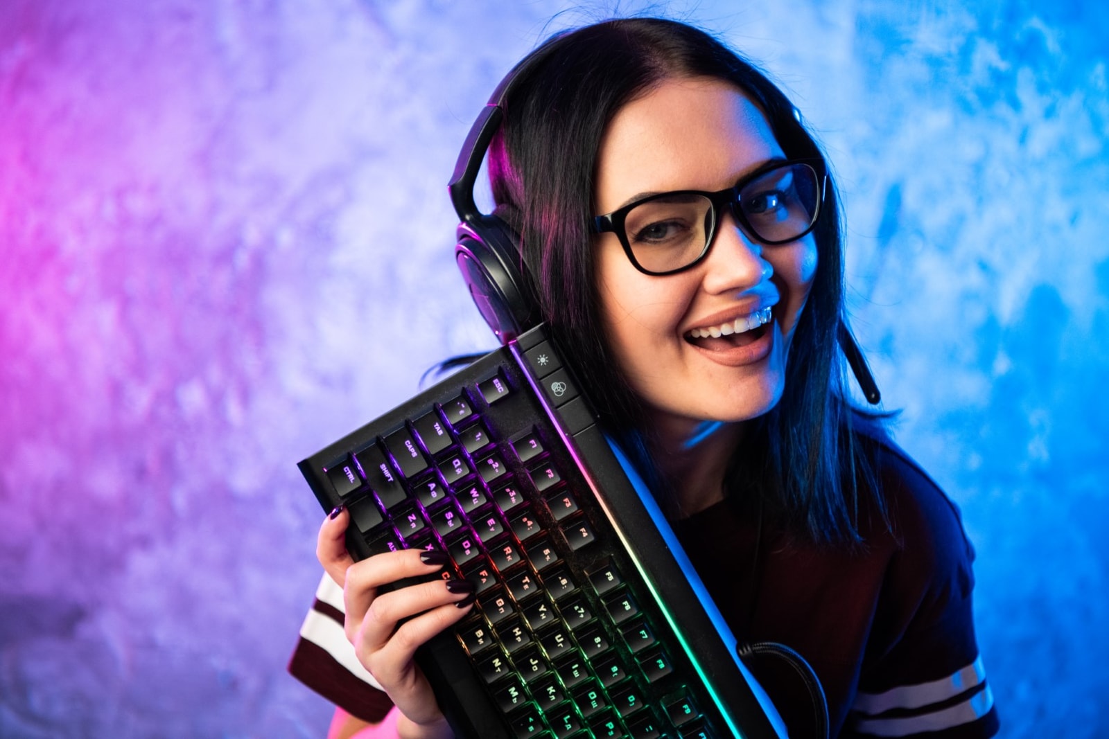 Gamer girl playing with computer at home. Young female posing with computer keyboard
